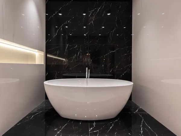 Modern bathroom with a white freestanding bath against a black marble feature wall